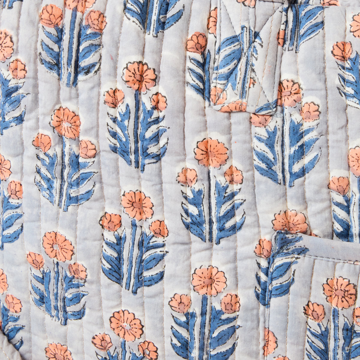 Quilted overnight duffel bag with blue background and orange flower pattern by Picnic Folk.